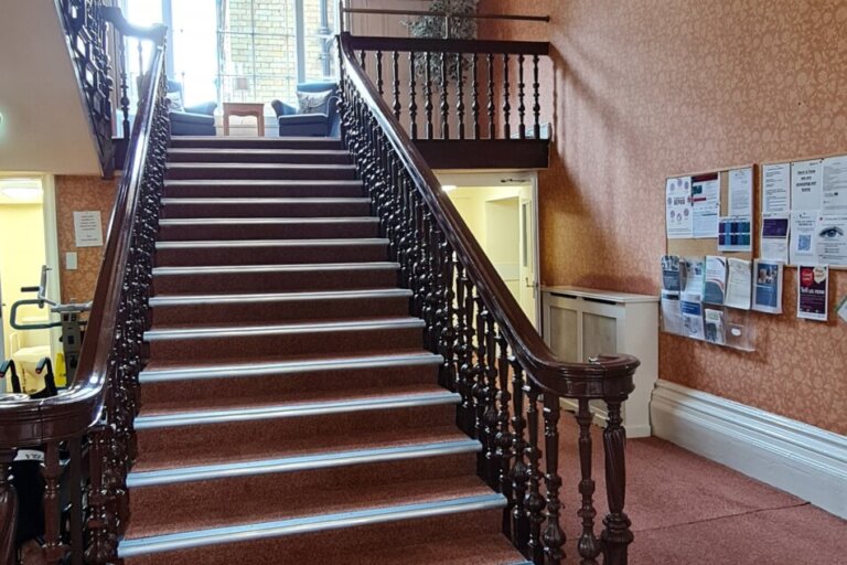 Admire the stunning staircase at Oaktree Hall and Lodge Care Home, a grand feature that enhances our welcoming environment.