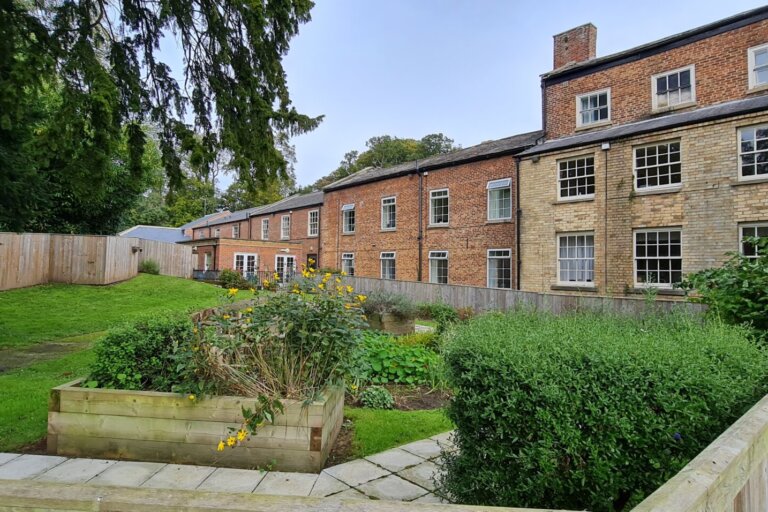 the picturesque rear view of the garden at Oaktree Hall & Lodge Care Home, showcasing the beauty and tranquility of our outdoor spaces.