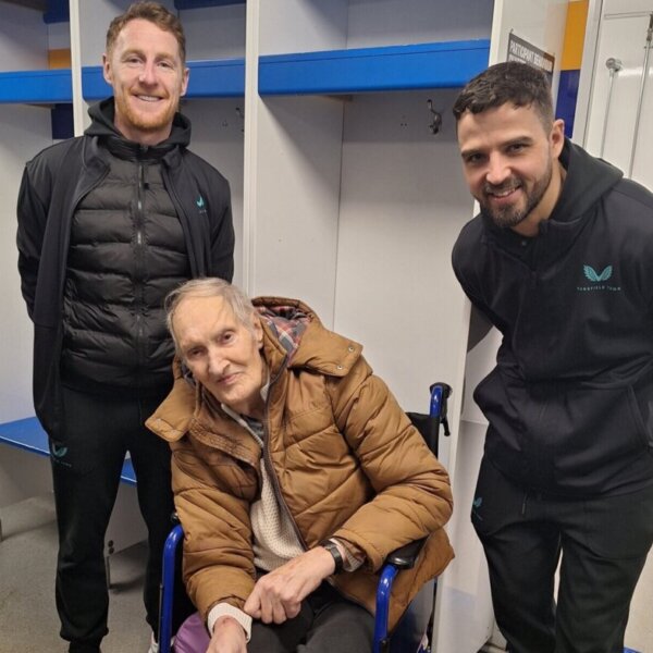 A resident from Clipstone Hall & Lodge Care Home with players from Mansfield Town FC