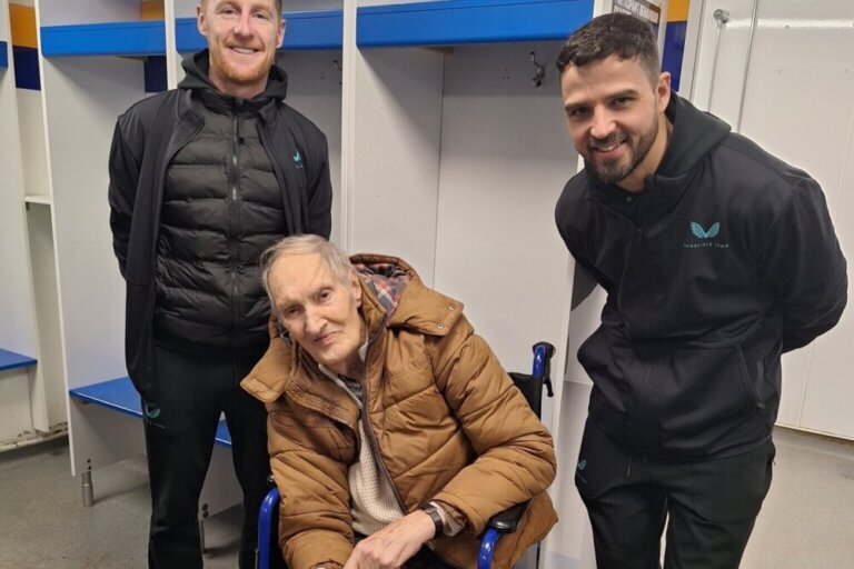 A resident from Clipstone Hall & Lodge Care Home with players from Mansfield Town FC
